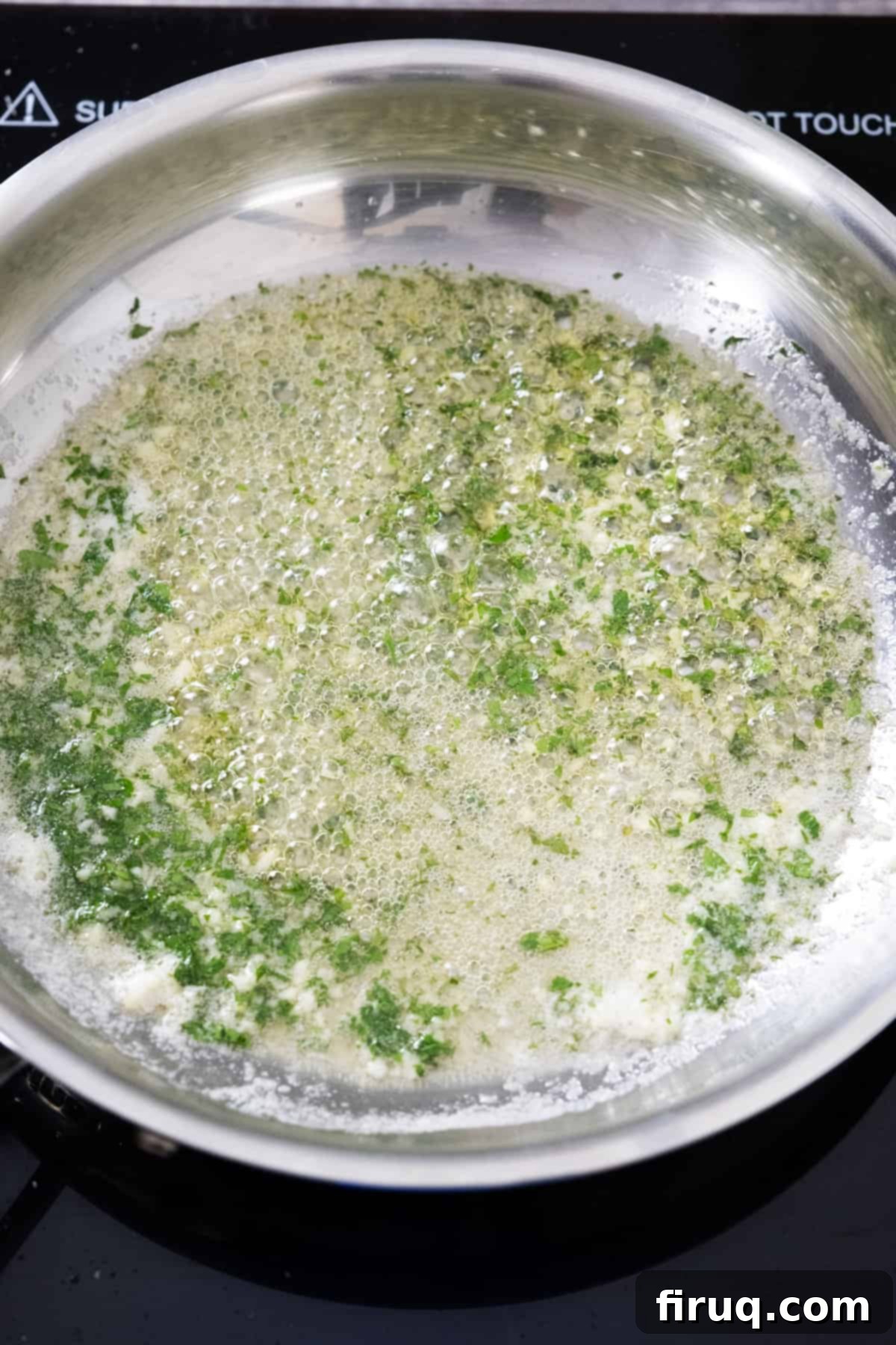 Crispy Air Fryer Garlic Parmesan Wings 6 Garlic butter sauce with fresh parsley simmering gently on low heat in a small saucepan, showing aromatic infusion