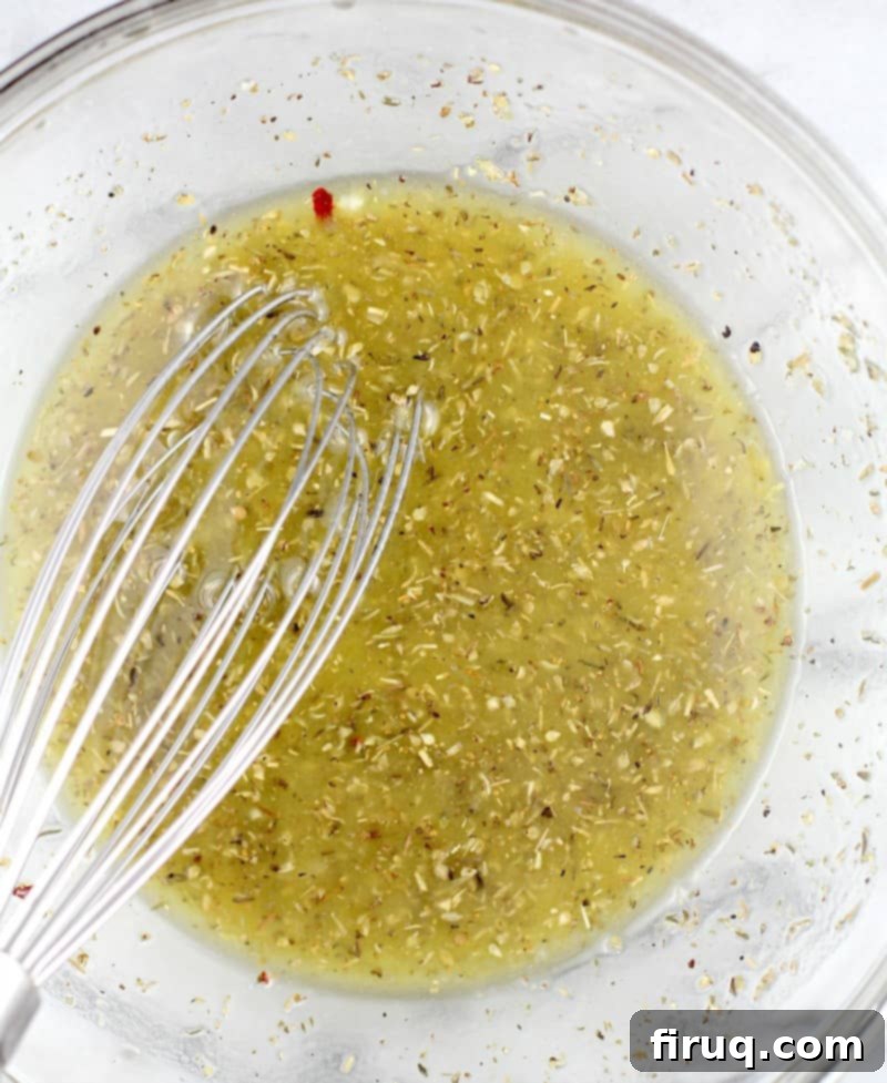 Crispy Greek Air Fryer Wings 3 top down view of the lemon herb marinade in a glass bowl with a whisk