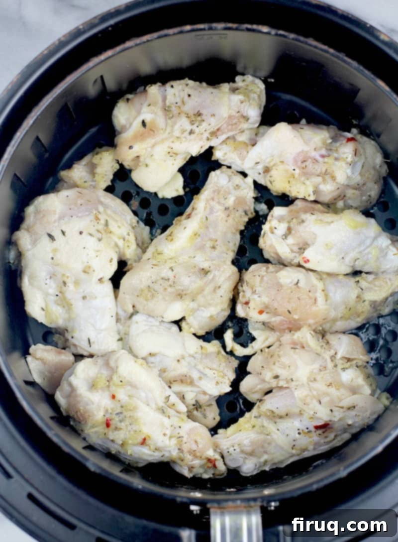 Crispy Greek Air Fryer Wings 6 raw Greek-style chicken wings in the air fryer basket before cooking