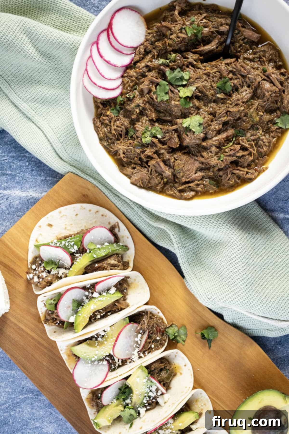 Ultimate Dutch Oven Barbacoa Tacos 8 Beef barbacoa in a bowl alongside tacos with sliced radish, avocado, and cotija cheese.