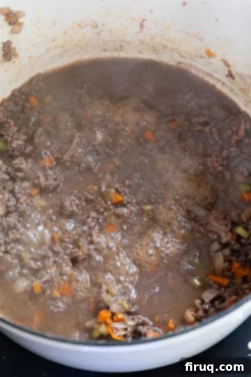 Classic Italian Stuffed Peppers in Tomato Sauce 7 Red wine simmering with ground beef and sofrito in a dutch oven