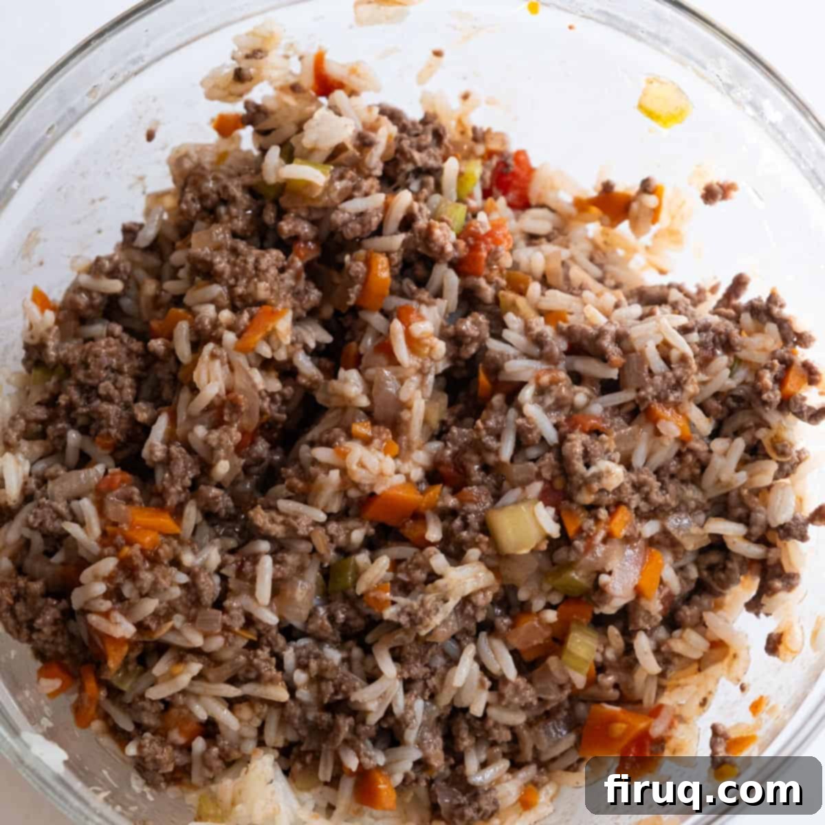 Classic Italian Stuffed Peppers in Tomato Sauce 9 Ground beef, cooked rice, fresh parsley, and parmesan cheese combined in a bowl with a spoonful of tomato sauce