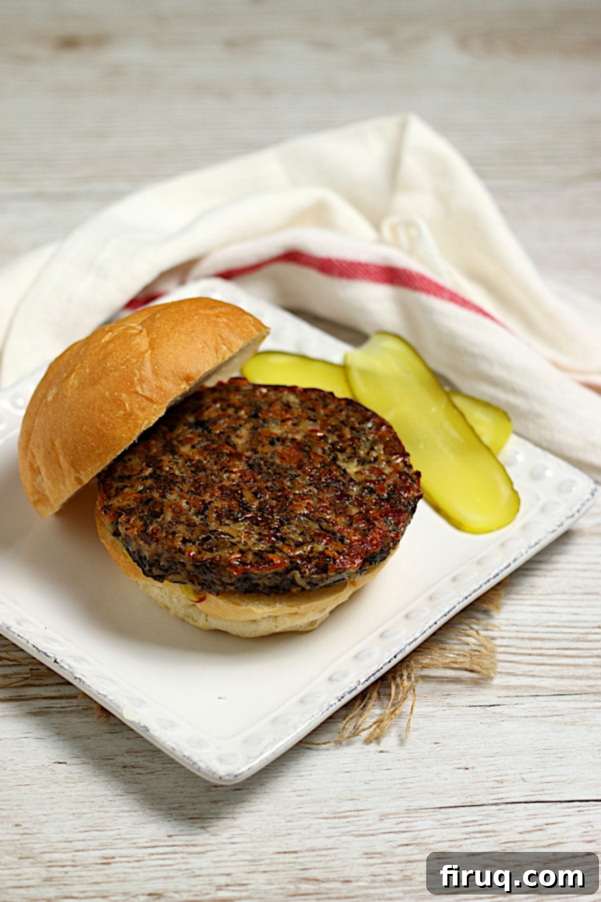 Delicious Mushroom Grain Veggie Burger A perfectly cooked Mushroom Grain Veggie Burger served on a white plate, ready to be topped.