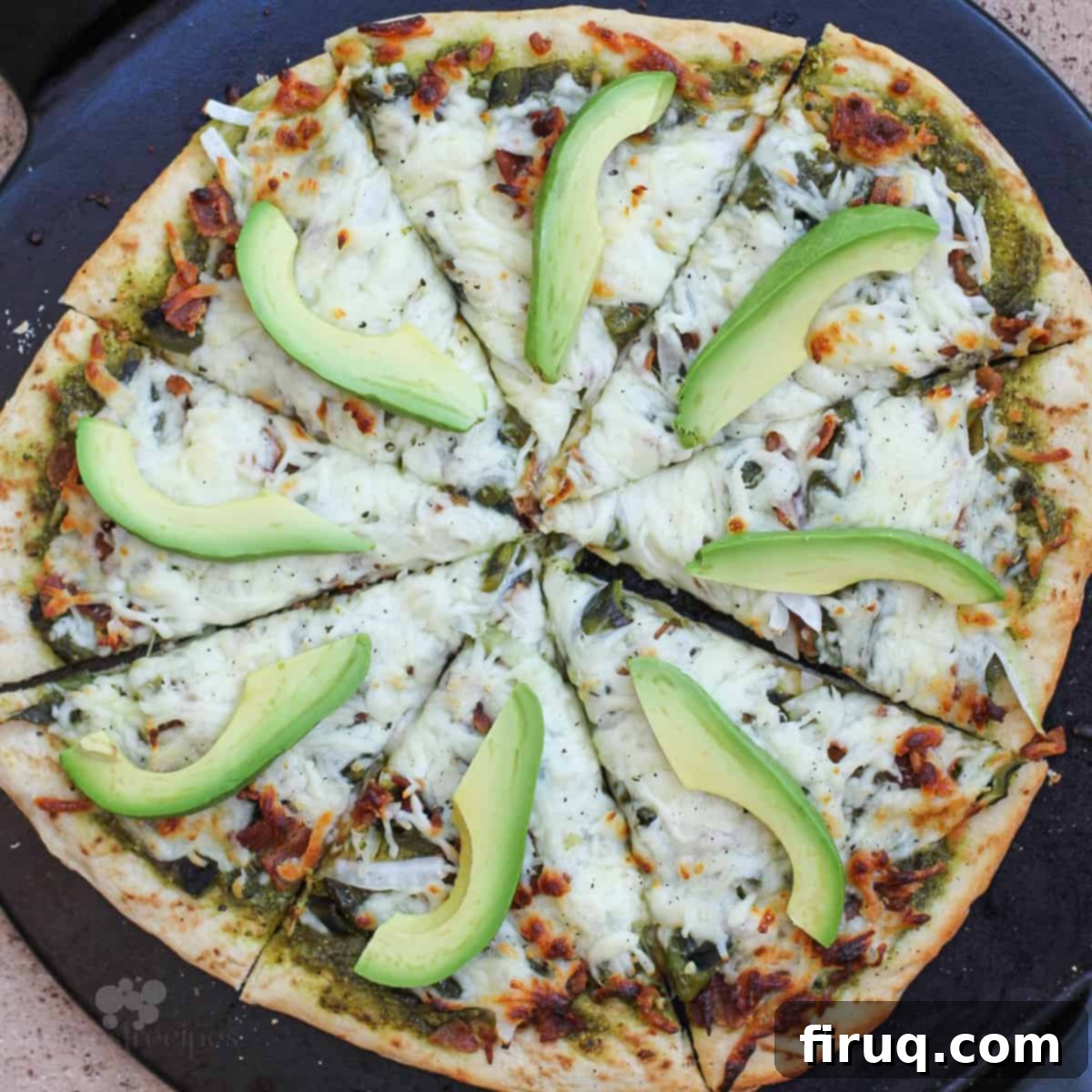 Smoky Roasted Poblano Pizza 2 cooked pizza on black pizza stone, topped with roasted poblanos, bacon, and cilantro pesto