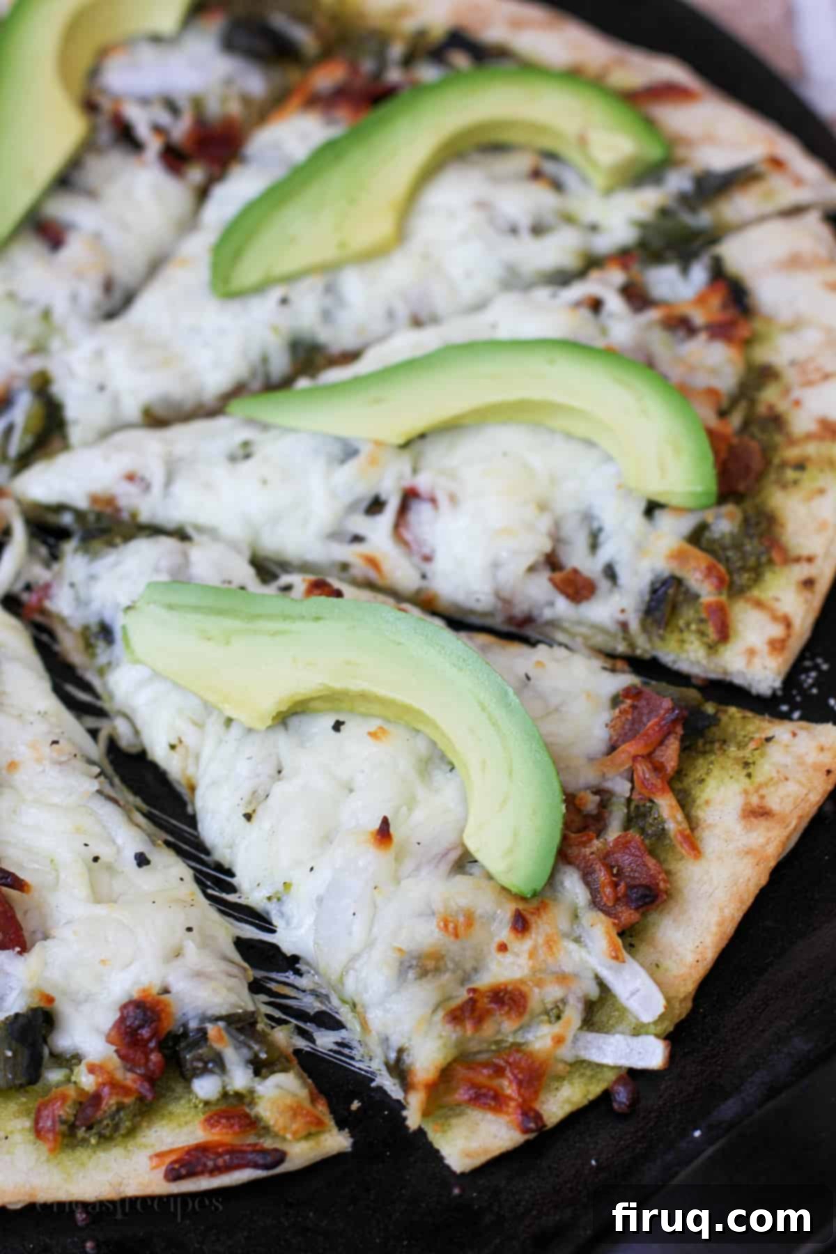 Smoky Roasted Poblano Pizza 3 sliced roasted poblano pizza on a black serving surface