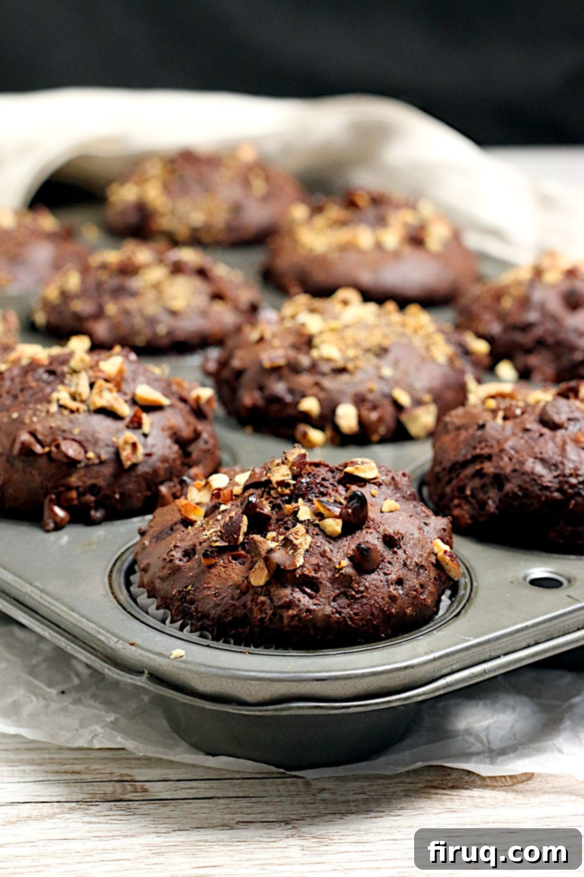 Homemade Chocolate Hazelnut Banana Muffins Chocolate Hazelnut Banana Muffins baking in a muffin pan, showing a golden crust and soft texture. A perfect blend of sweet and nutty flavors.