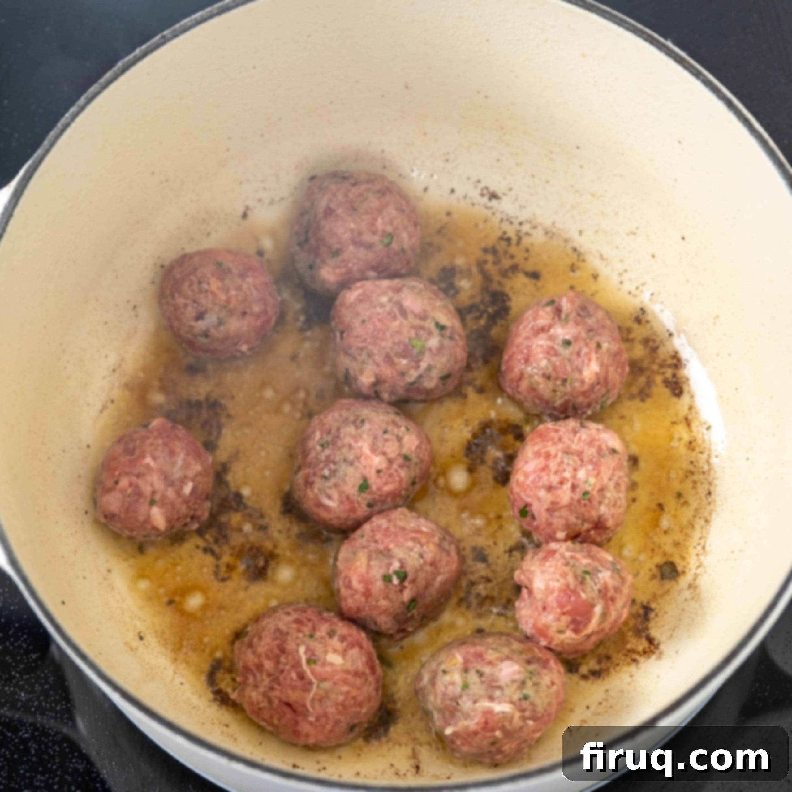 Classic Italian Wedding Soup 5 Small Italian meatballs frying in olive oil in a pot