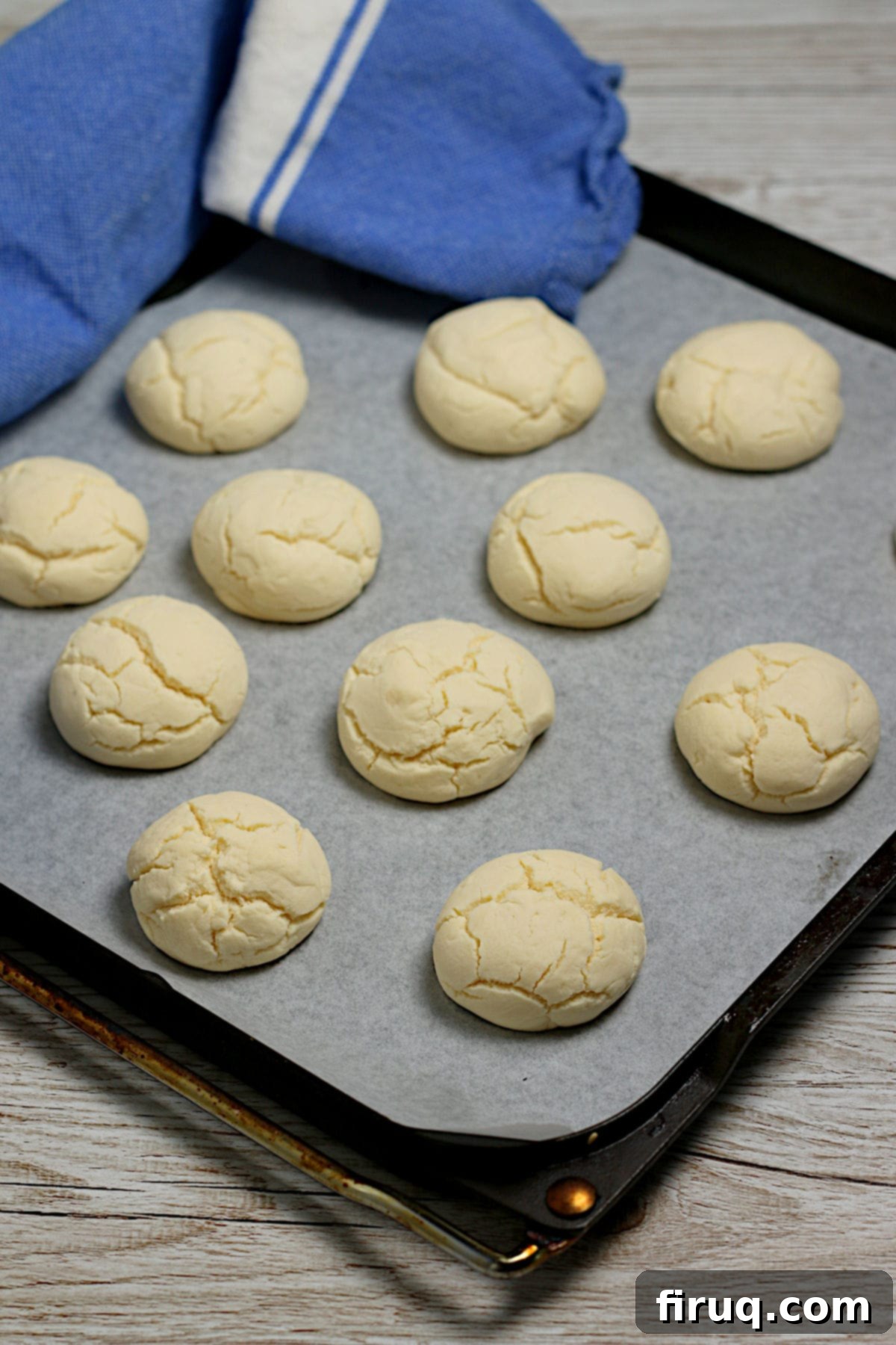 Freshly baked cornstarch cookies on parchment paper Cornstarch cookies (sequilhos) on a parchment-lined baking sheet.