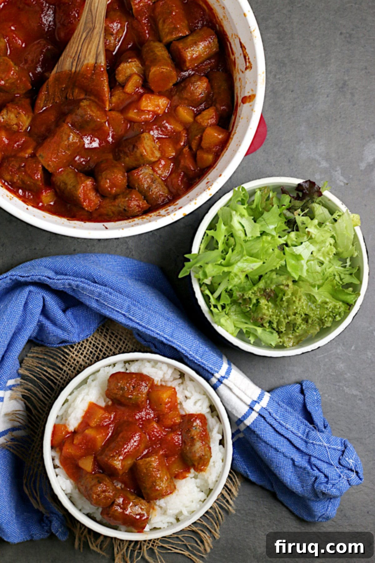 Overhead view of Peachy Sweet and Sour Sausages Overhead photo of Peachy Sweet and Sour Sausages over white rice in a black bowl.