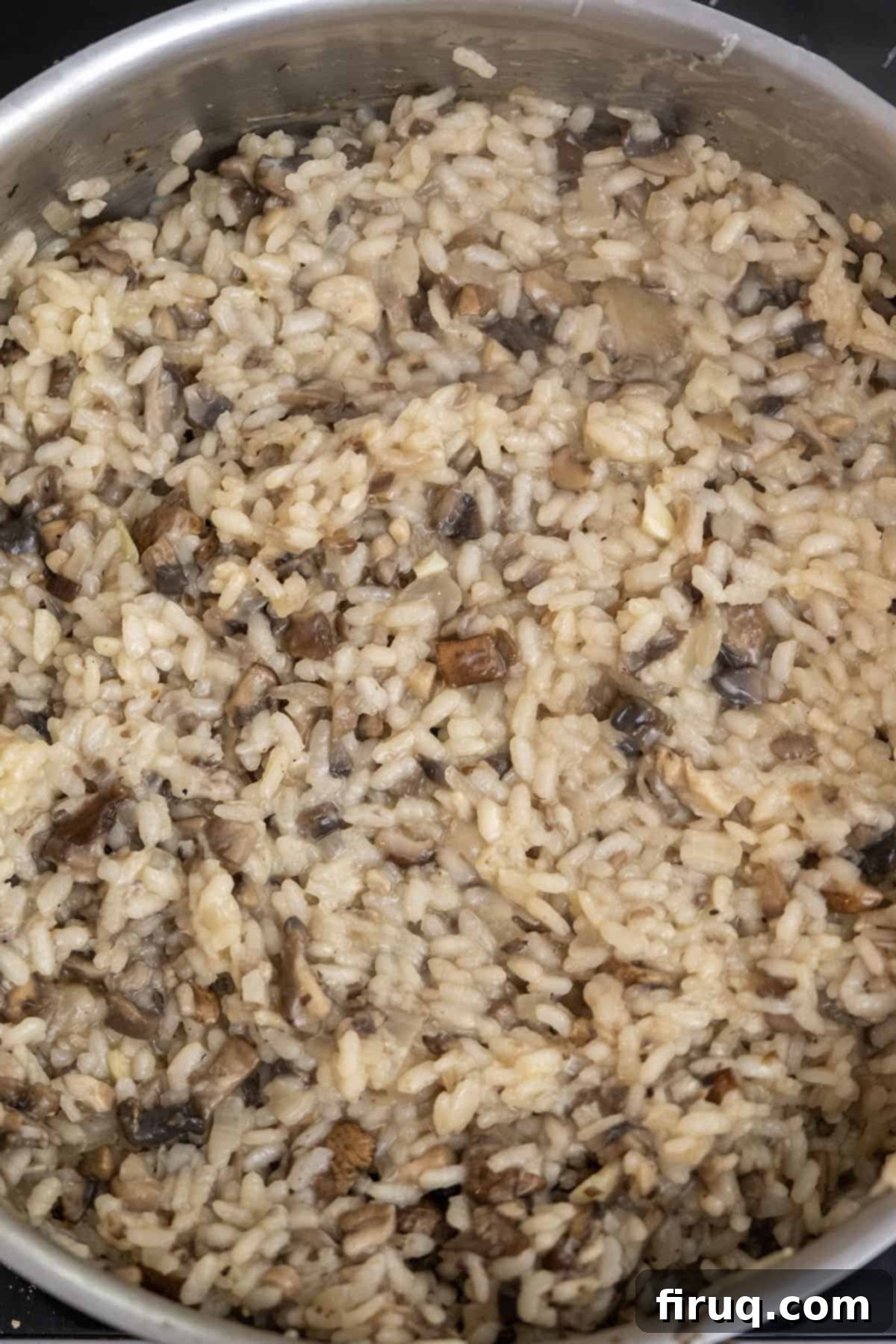 Decadent Mushroom Truffle Risotto 10 The final step of the risotto making process, adding mushrooms, Parmesan cheese, truffle oil, and butter for richness.