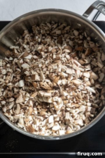 Decadent Mushroom Truffle Risotto 4 Raw assorted mushrooms being sautéed in olive oil in a large saucepan.