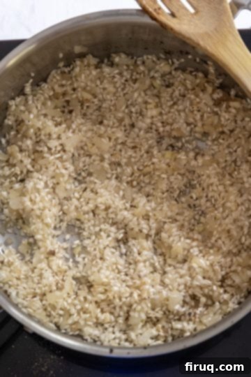 Decadent Mushroom Truffle Risotto 9 White wine being added to the toasted Arborio rice in the pan.