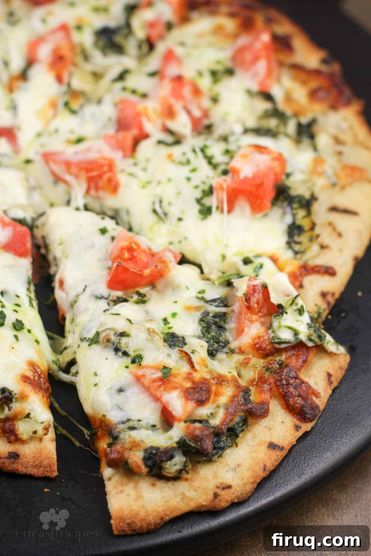 Creamy Spinach Artichoke Indulgence 3 sliced pizza on pizza stone
