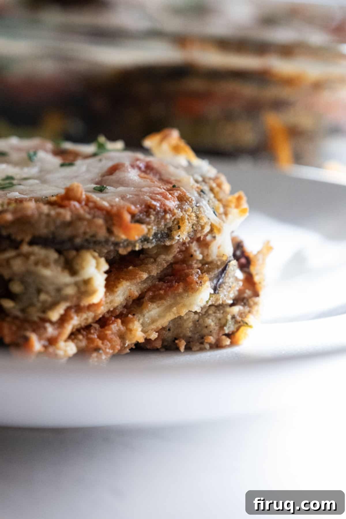 The Ultimate Homemade Eggplant Parmigiana 12 Large, generous slice of homemade eggplant parmesan on a plate, ready to be enjoyed.