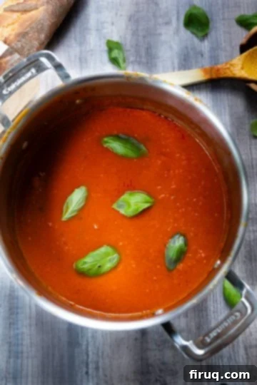 The Ultimate Homemade Eggplant Parmigiana 3 Sunday sauce simmering in a pot, ready for layering.