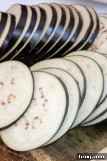 The Ultimate Homemade Eggplant Parmigiana 4 Eggplant uniformly sliced into ¼-inch rounds, ready for preparation.