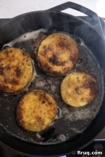 The Ultimate Homemade Eggplant Parmigiana 7 Eggplant slices frying to a golden brown in olive oil.