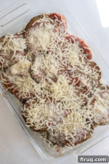 The Ultimate Homemade Eggplant Parmigiana 10 Eggplant Parmigiana topped with mozzarella, ready for baking.