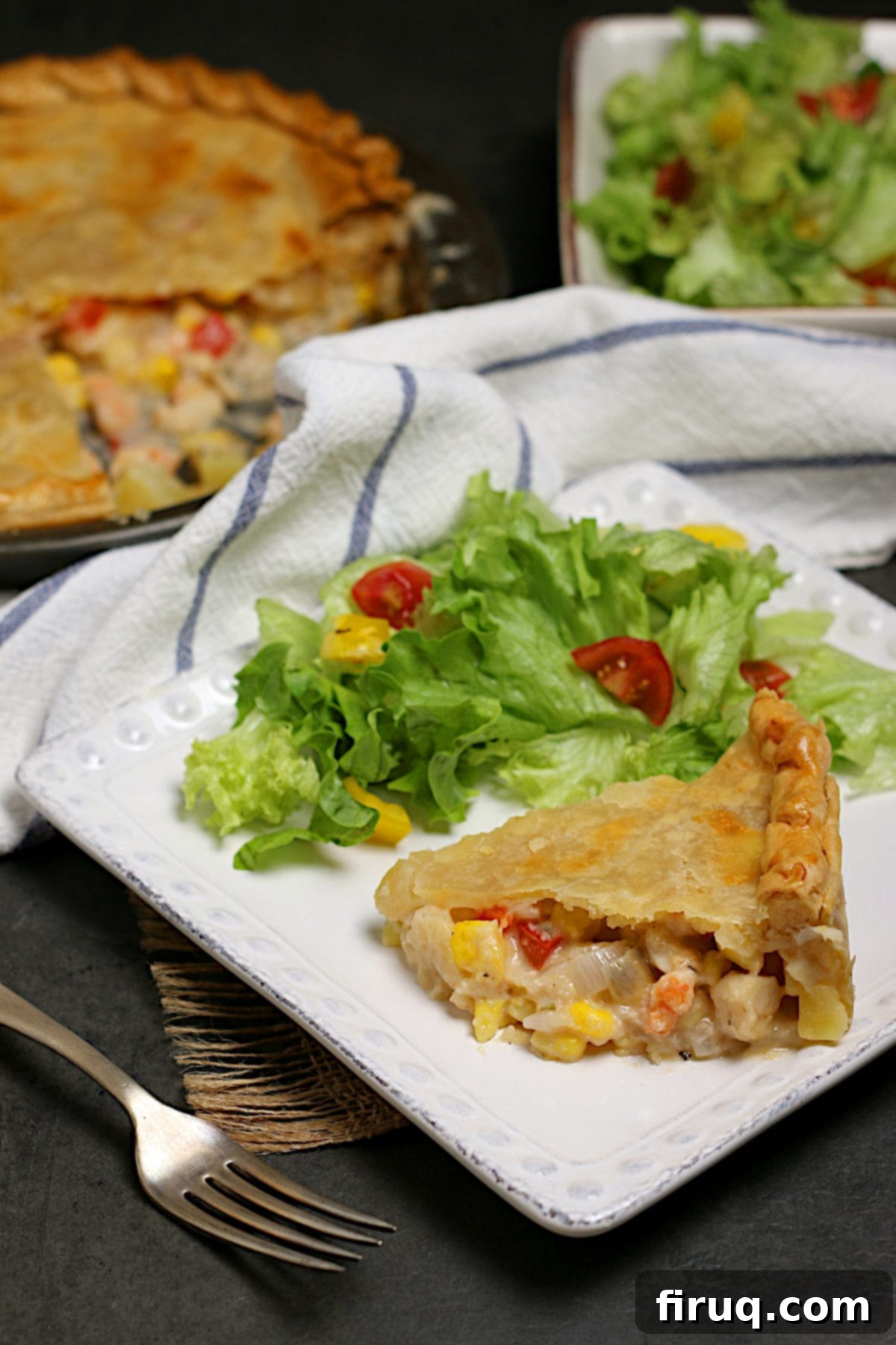 Seafood Pie with Side Salad A delicious slice of seafood pie served on a white plate with a fresh side salad.