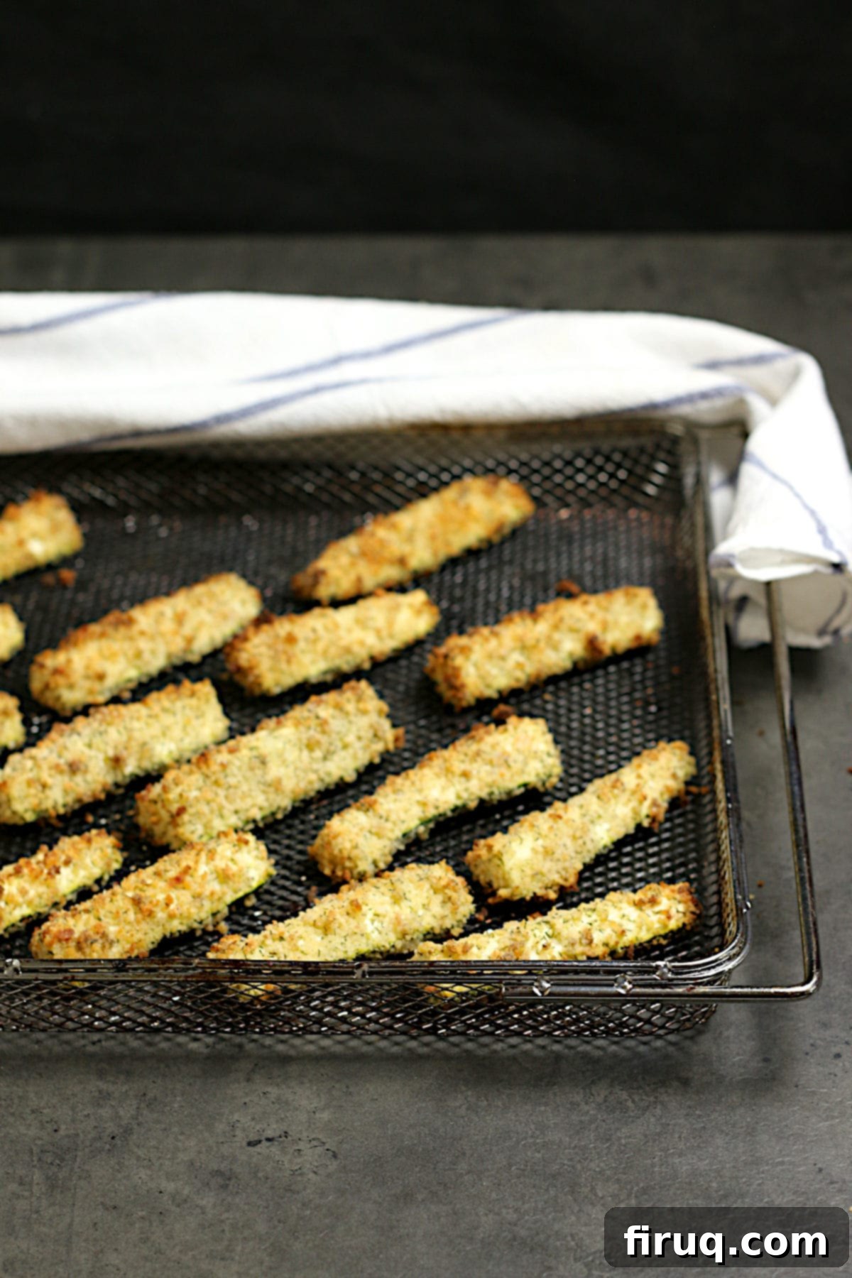 Perfectly Crispy Air-Fried Zucchini Sticks Golden brown Air-Fried Zucchini Sticks neatly arranged on an air fryer tray, ready to be served.