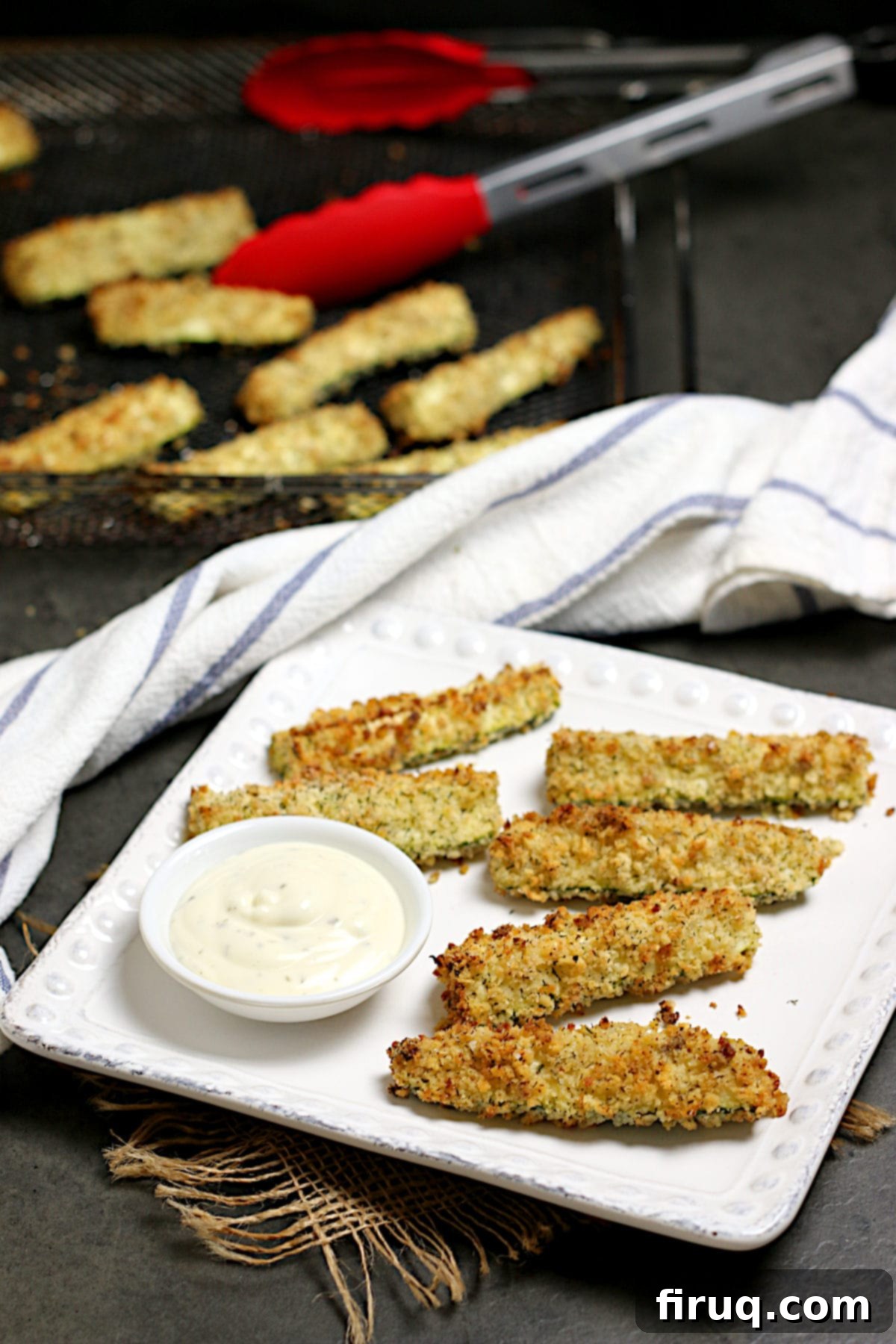 Delicious Air-Fried Zucchini Sticks Air-fried zucchini sticks beautifully arranged on a white square plate, ready to be enjoyed as a side or snack.