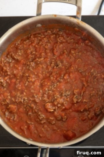 Hearty Stuffed Shells with Bolognese and Ricotta 7 adding the meat back to the sauce