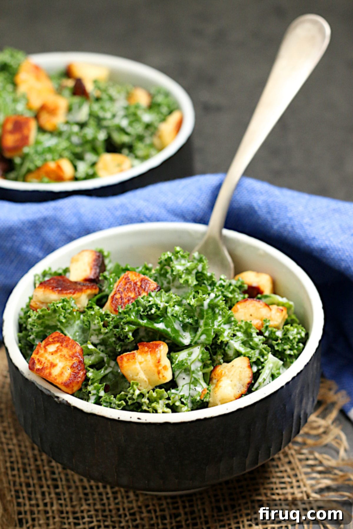 Kale Caesar Salad with Halloumi Croutons Kale Caesar Salad with Halloumi croutons in a black bowl.