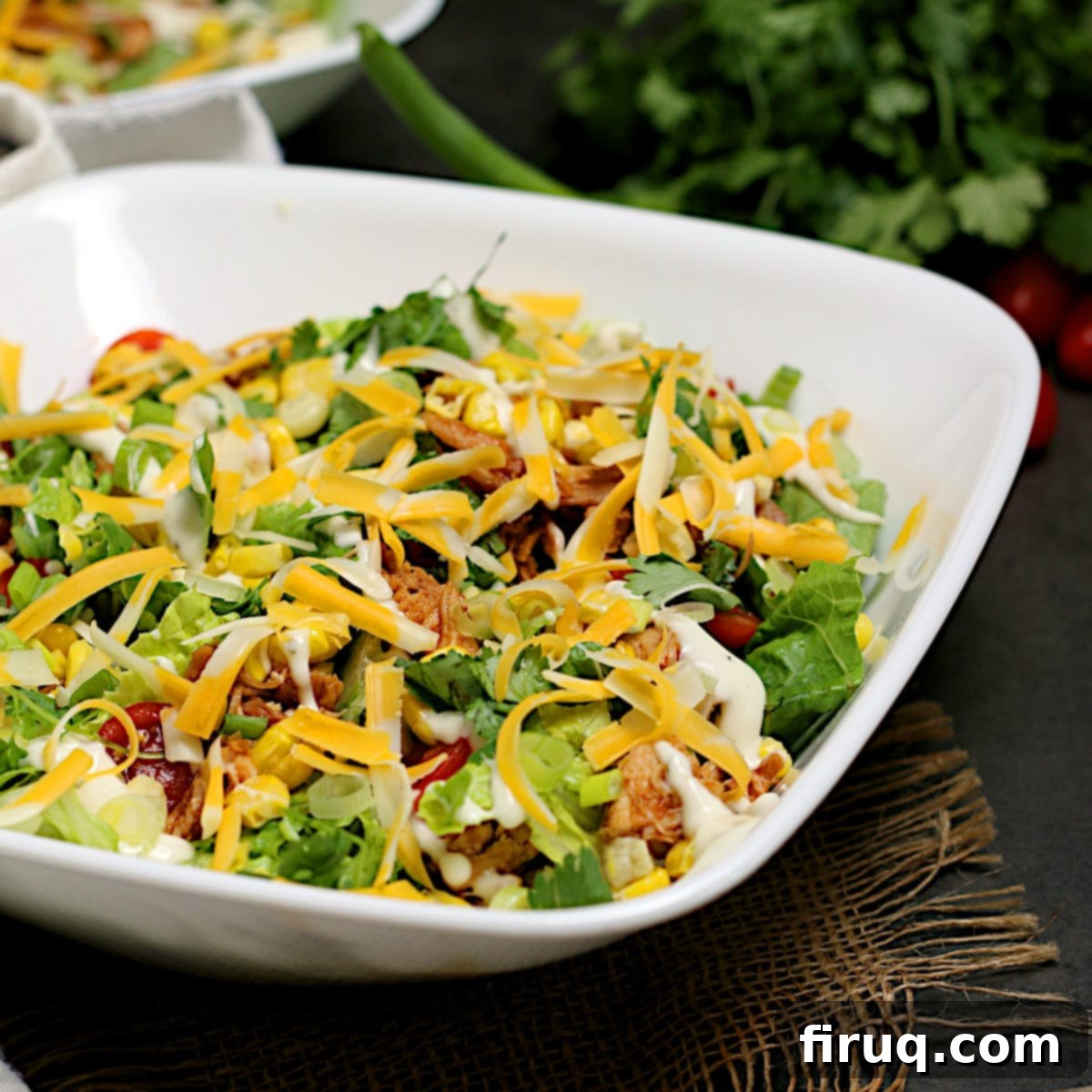 Ranch-Drizzled BBQ Chicken Salad 2 Barbecue Chicken Ranch Salad in a white bowl, garnished with fresh herbs.