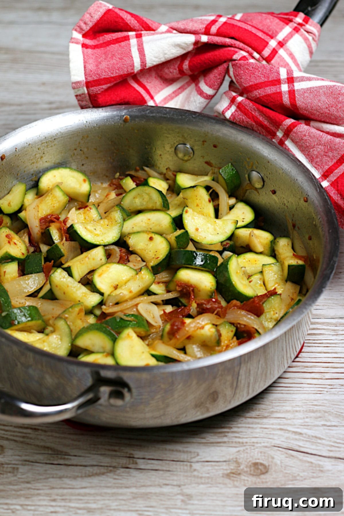 Sautéed Zucchini with Sun-Dried Tomatoes and Onions Zucchini with Sun-Dried Tomatoes and Onions in a saute pan.