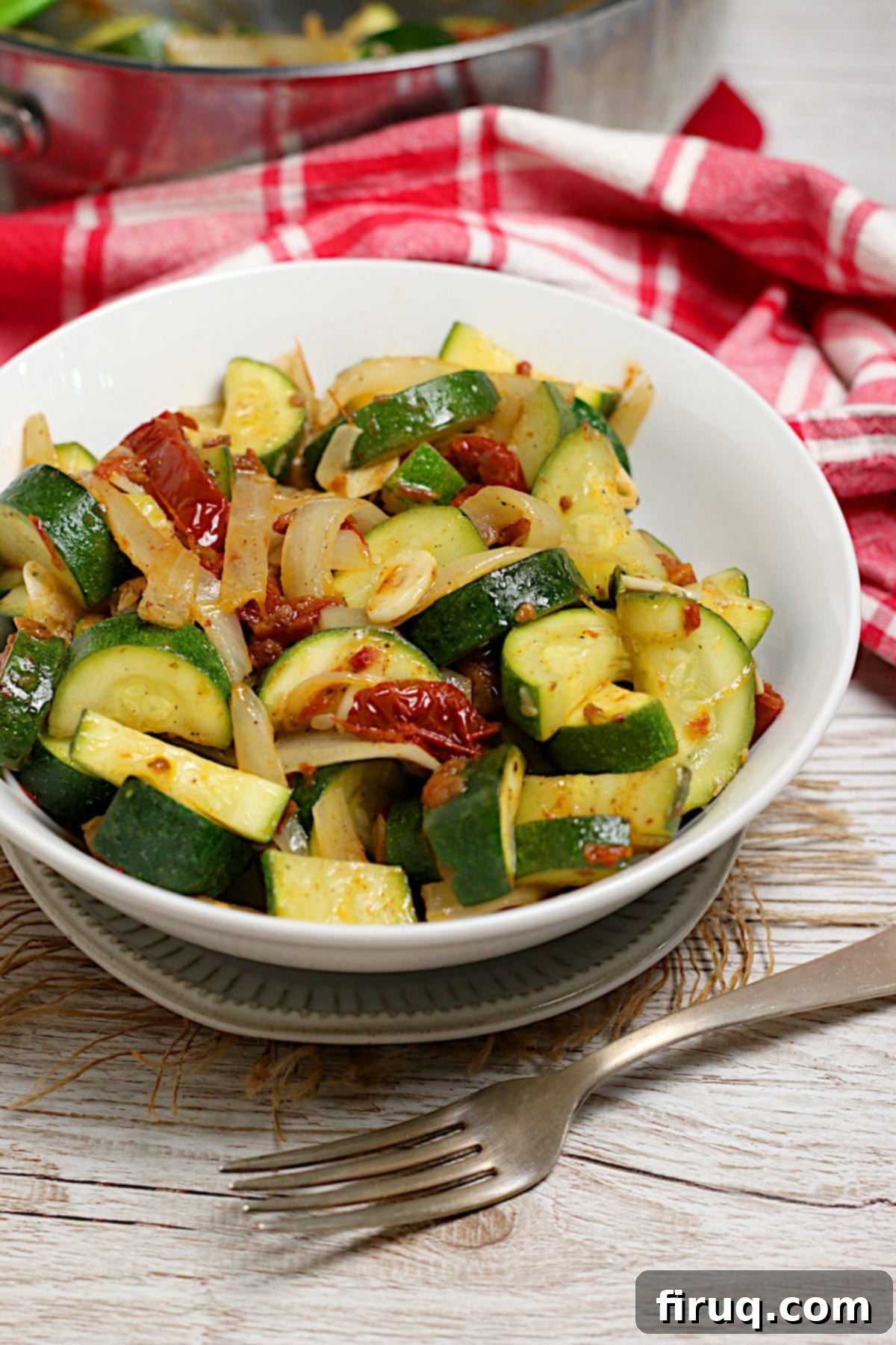 Fresh Zucchini with Sun-Dried Tomatoes and Onions Zucchini with Sun-Dried Tomatoes and Onions in a white bowl.