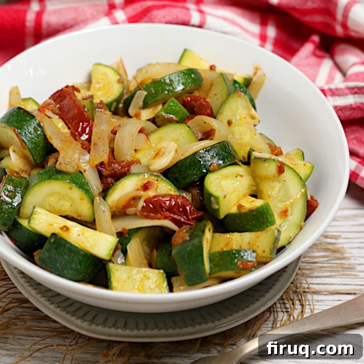Zucchini with Sun-Dried Tomatoes and Onions Recipe Zucchini with Sun-Dried Tomatoes and Onions in a white bowl.