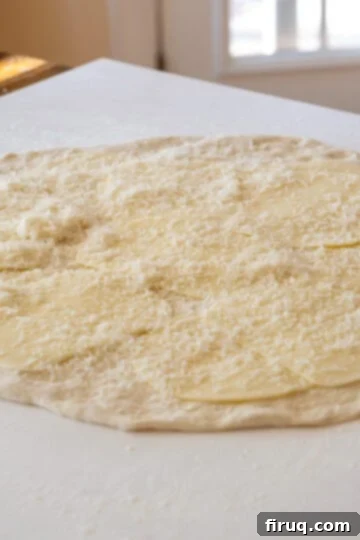 Savory Pepperoni Spiral 3 Pizza dough rolled out and evenly topped with generous layers of three different cheeses, creating a savory base.