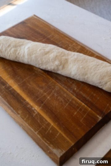 Savory Pepperoni Spiral 5 Pizza dough tightly rolled into a log, filled with pepperoni and cheese, ready for slicing.