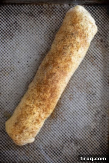Savory Italian Sausage Bread 8 The rolled bread loaf, brushed with egg wash and seasoned with paprika, garlic powder, salt, and pepper.