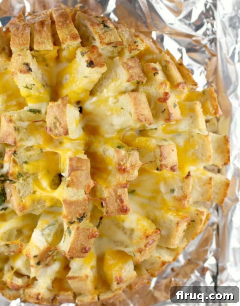 Loaded Cheesy Garlic Bread 10 Top-down view of the finished stuffed cheesy bread on foil, ready to be pulled apart and served.