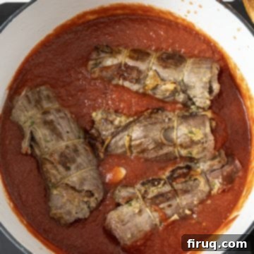 Slow-Simmered Italian Braciole Perfection 11 Braciole added to tomato sauce, half-covered for braising