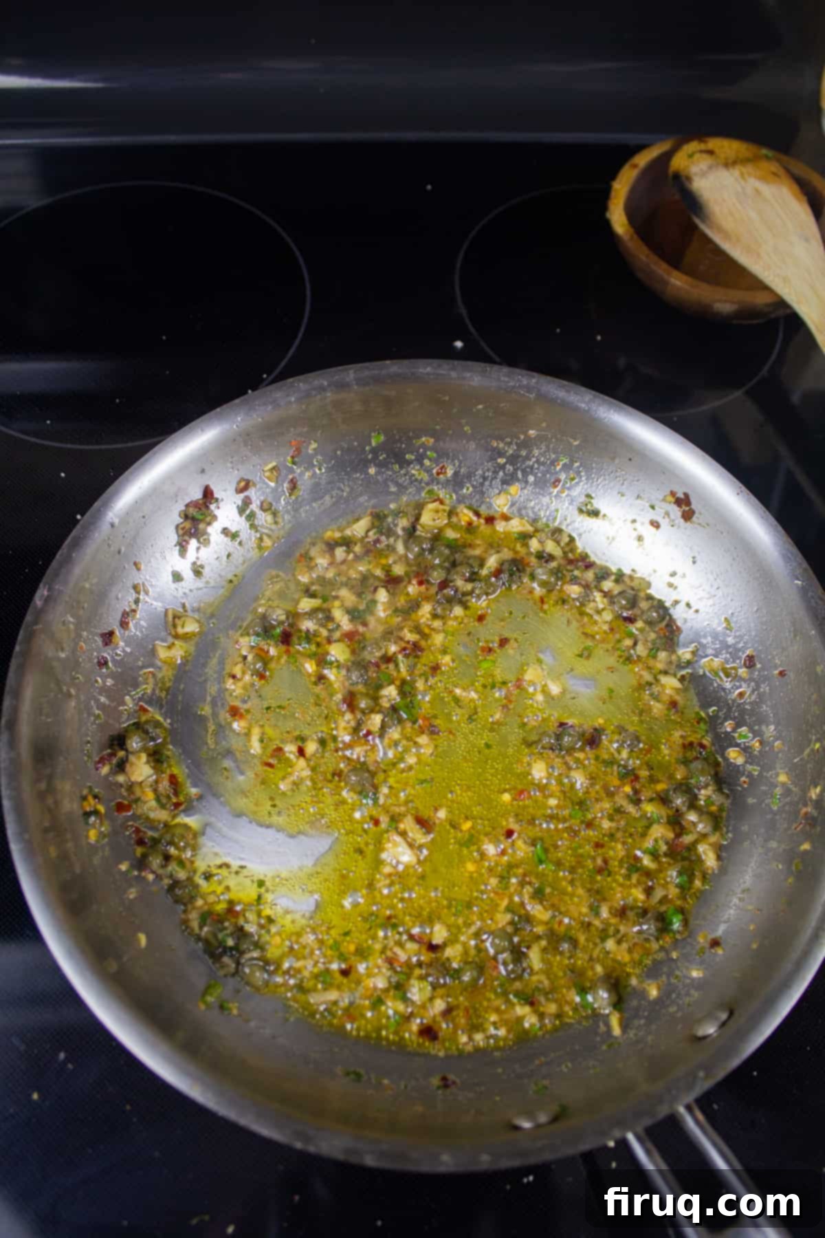 Crispy Breadcrumb Anchovy Garlic Pasta 4 Garlic, Anchovy, capers, and parsley in olive oil in a pan on the stove, forming the sauce base