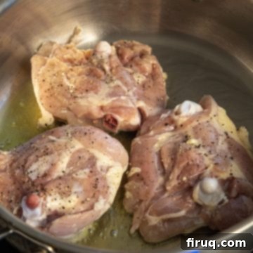 Crimson Wine Fennel Chicken Thighs 3 Searing bone-in chicken thighs skin-side down in a hot pan to achieve a golden-brown, crispy skin.