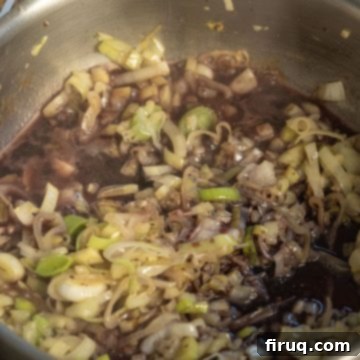 Crimson Wine Fennel Chicken Thighs 6 Dry red wine being poured into the pan to deglaze and simmer with the sautéed aromatics.