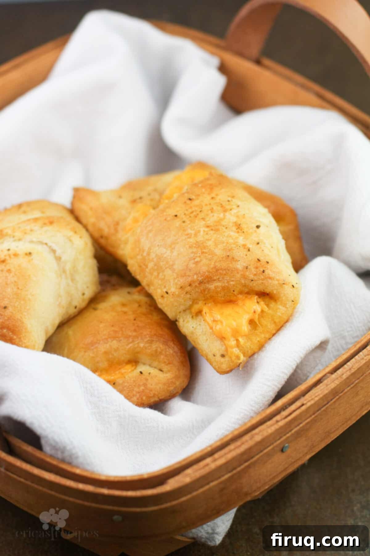 Melted Cheddar Crescent Rolls 7 A close-up of baked cheddar cheese stuffed crescent rolls in a basket, showing their fluffy texture.
