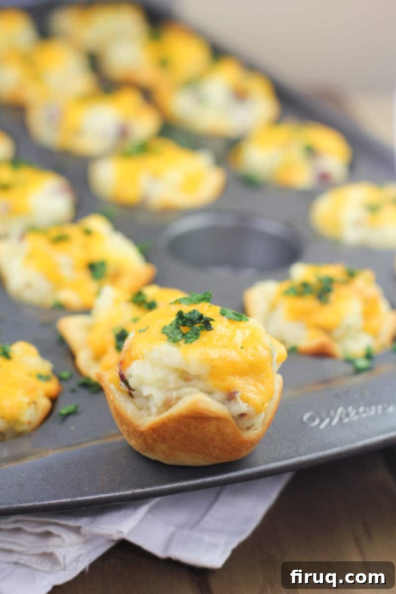 Creamy Ranch Mashed Potato Cups 2 Close-up of golden brown Ranch Mashed Potato Cups with creamy filling and bacon, garnished with chives.