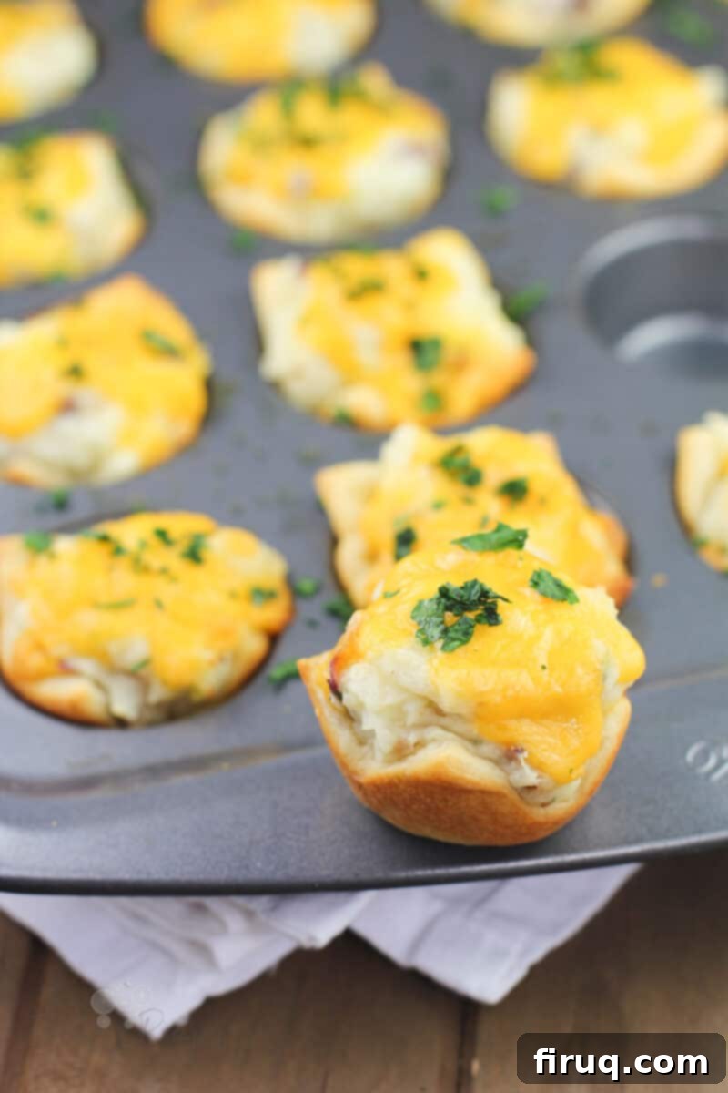 Creamy Ranch Mashed Potato Cups 12 single potato cup sitting on the rim of muffin pan, freshly baked