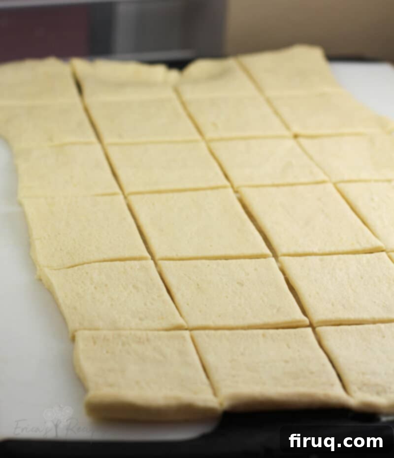 Creamy Ranch Mashed Potato Cups 10 crescent dough sheet on white board cut into 24 squares, demonstrating how to prepare the dough