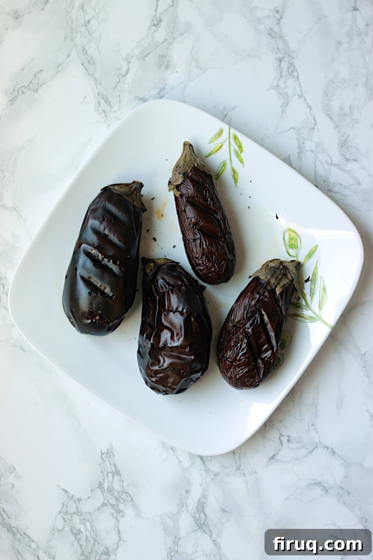 Roasted Eggplant for Baba Ghanouj Roasted eggplants on a plate, ready to be prepared for Baba Ghanouj.