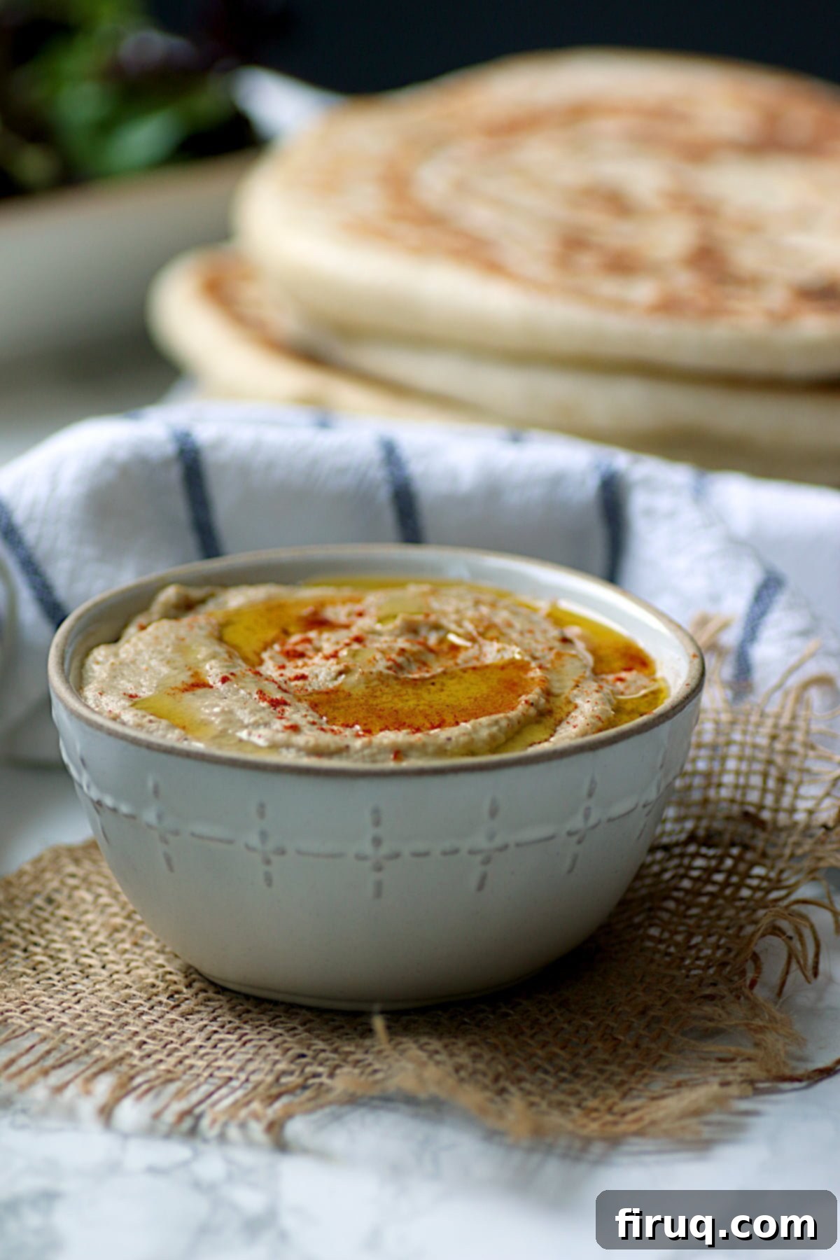 Garnished Baba Ghanouj Homemade baba ghanouj in a white bowl, garnished with olive oil and paprika.