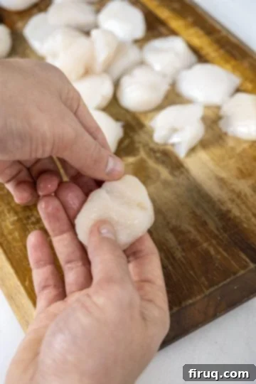 Sizzling Garlic Sage Scallops 3 carefully peeling the adductor muscle from a scallop edge