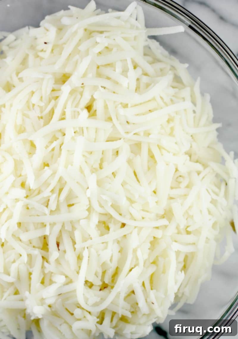 Kickin' Hash Brown Popper Casserole 4 Bowl of freshly shredded hash brown potatoes, ready to be mixed into a casserole, highlighting their texture.