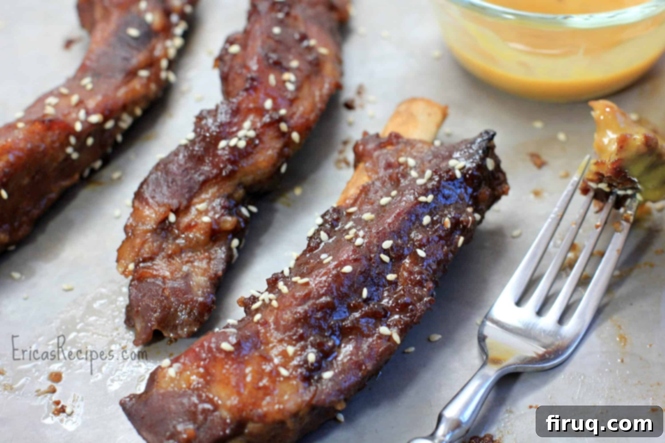Sweet and Sticky Chinese Pork Ribs 2 Platter of glossy, red Chinese BBQ Pork Spareribs with sesame seeds and dipping sauce