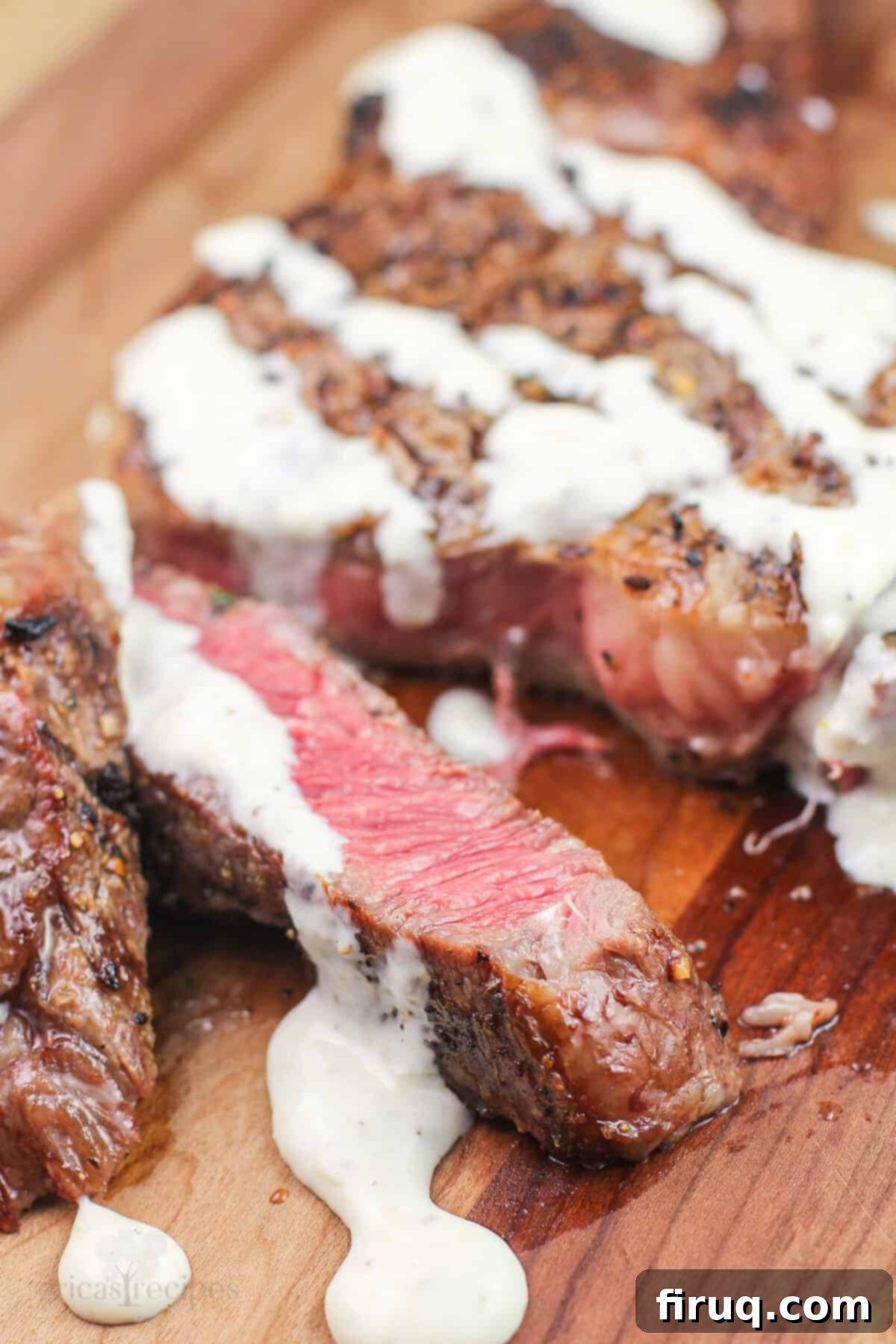 Grilled Steak with Zesty Horseradish Dijon 2 Sliced grilled steak on a wooden board, generously topped with creamy horseradish Dijon sauce, showcasing a perfect medium-rare doneness.