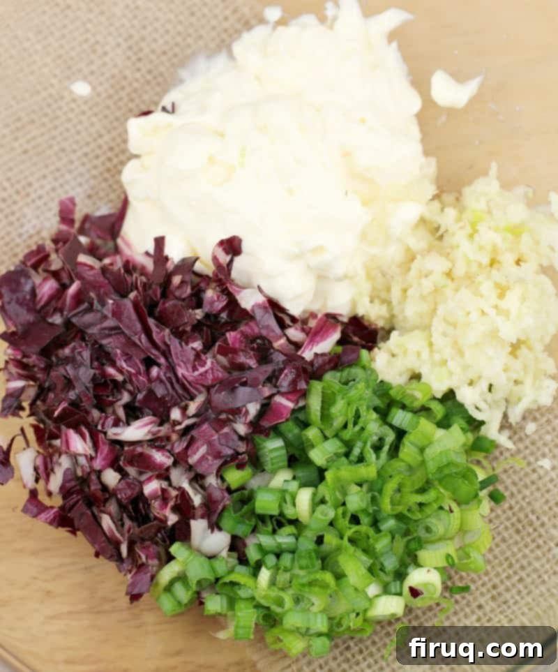 Imperial Russian Garlic Cheese 3 Ingredients for Russian Garlic Cheese Spread, including shredded Havarti, minced garlic, mayonnaise, green onion, and radicchio, gathered in a glass bowl before mixing.
